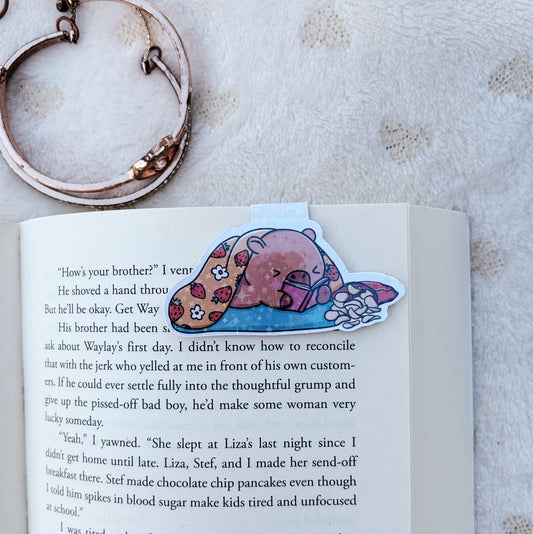 Capybara laying down and reading magnetic bookmark